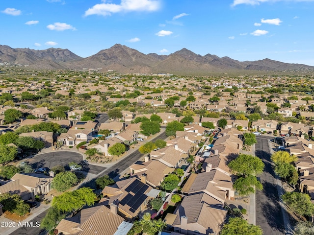 aerial view of property's location with nearby suburban area and a mountainous background