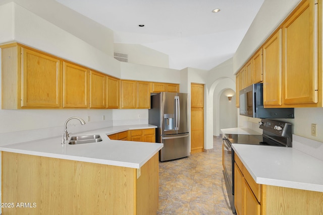 kitchen featuring appliances with stainless steel finishes, a sink, a peninsula, light countertops, and arched walkways
