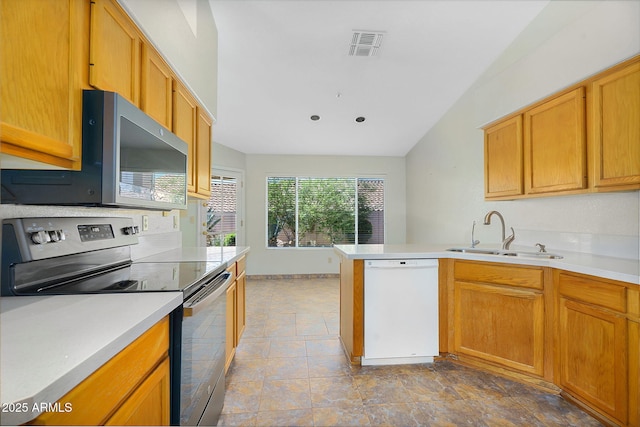 kitchen with appliances with stainless steel finishes, a sink, light countertops, a peninsula, and lofted ceiling
