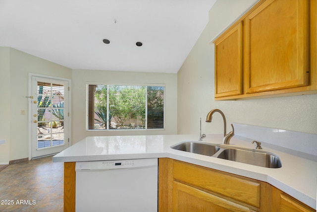 kitchen featuring dishwasher, a sink, a peninsula, and light countertops