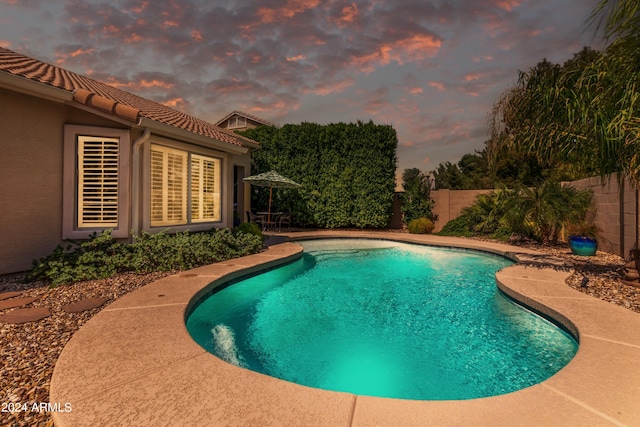 view of pool at dusk