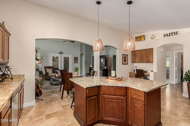 kitchen featuring pendant lighting, a center island, lofted ceiling, and light stone counters