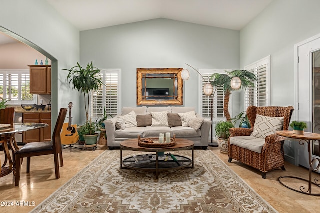 sitting room featuring light tile patterned flooring and lofted ceiling