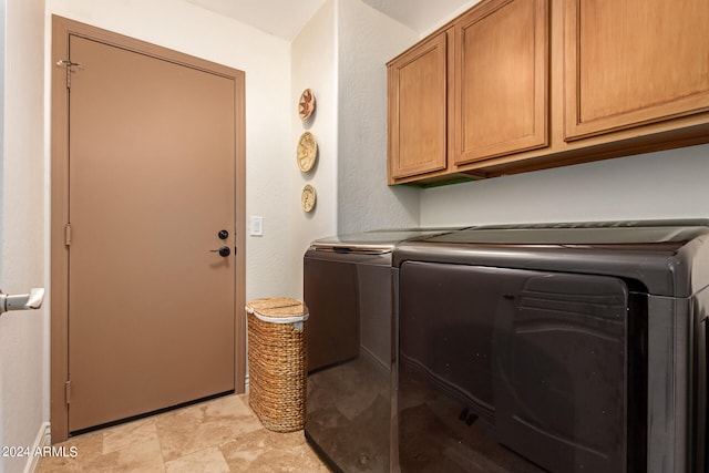 laundry room with cabinets and washing machine and clothes dryer