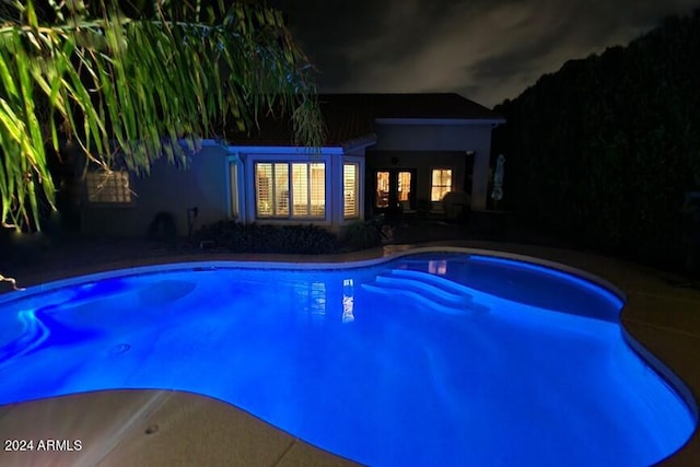 view of pool at twilight