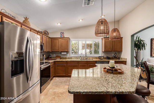 kitchen featuring a kitchen island, vaulted ceiling, sink, hanging light fixtures, and appliances with stainless steel finishes