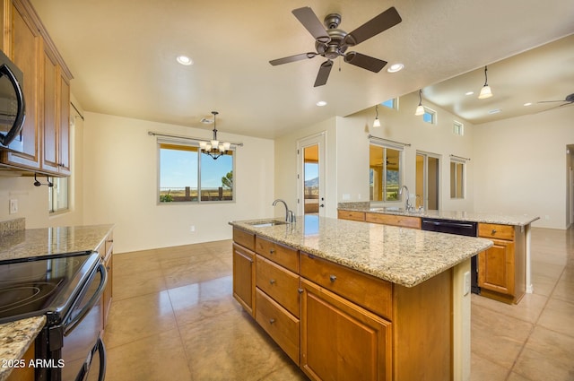 kitchen featuring black appliances, an island with sink, sink, and decorative light fixtures