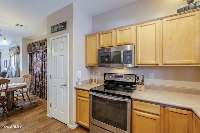 kitchen with light hardwood / wood-style floors, stainless steel appliances, and light brown cabinets