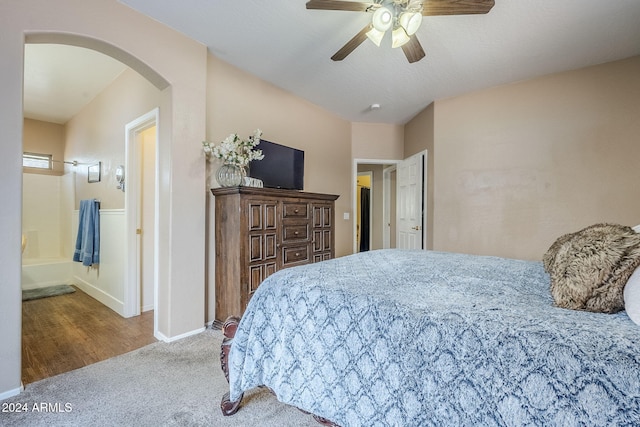 carpeted bedroom with ceiling fan and ensuite bath