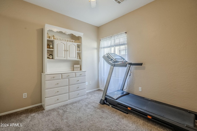 workout room featuring light carpet and ceiling fan