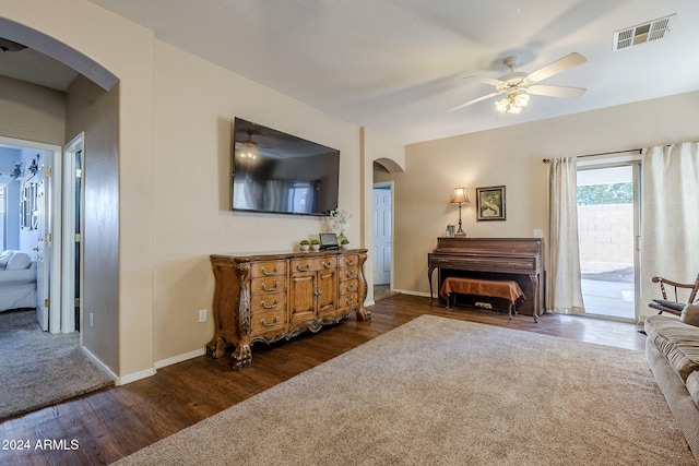 living room with dark hardwood / wood-style flooring and ceiling fan