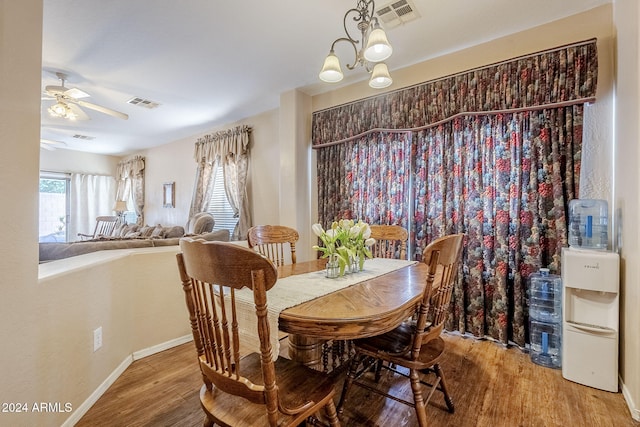 dining area featuring hardwood / wood-style floors and ceiling fan with notable chandelier