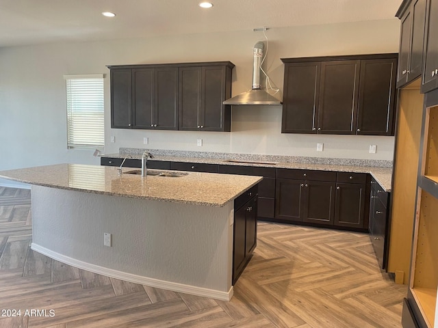 kitchen featuring wall chimney range hood, sink, black electric cooktop, and light parquet flooring