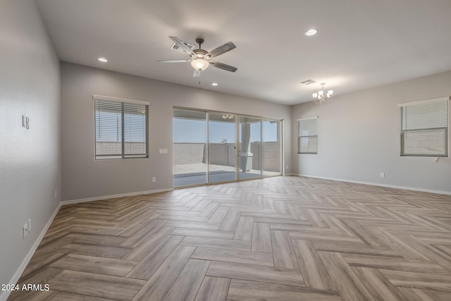 spare room with light parquet floors and ceiling fan with notable chandelier