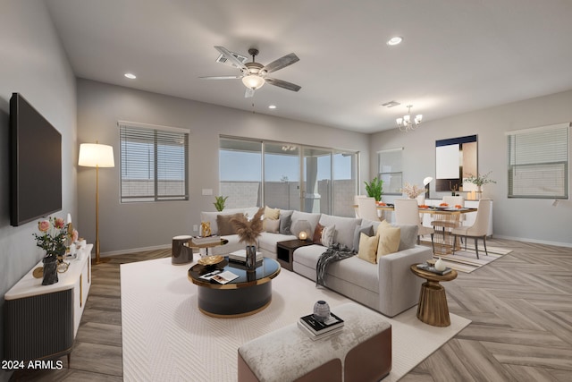 living room with parquet floors and ceiling fan with notable chandelier