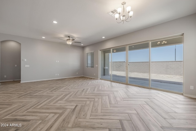 unfurnished room with ceiling fan with notable chandelier and light parquet flooring