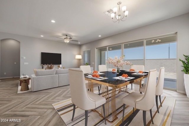 dining space featuring ceiling fan with notable chandelier and light parquet flooring