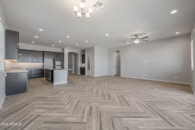 unfurnished living room with sink, ceiling fan with notable chandelier, and light parquet floors