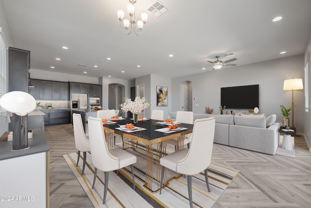 dining room featuring ceiling fan with notable chandelier and light parquet flooring