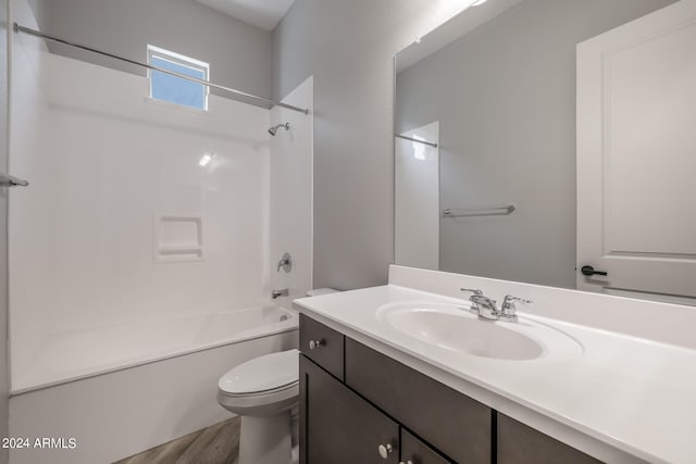 full bathroom with washtub / shower combination, wood-type flooring, toilet, and large vanity