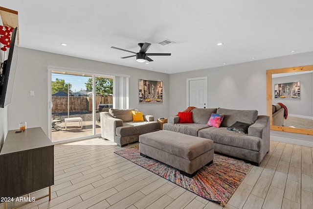 living room featuring light hardwood / wood-style floors and ceiling fan