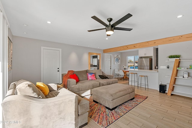 living room with beam ceiling, ceiling fan, and light hardwood / wood-style floors