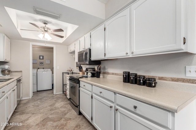 kitchen featuring white cabinets, appliances with stainless steel finishes, ceiling fan, and washing machine and clothes dryer