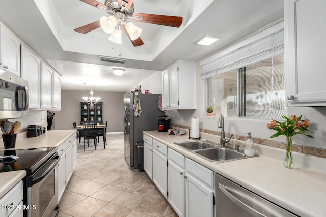 kitchen featuring white cabinets, ceiling fan with notable chandelier, stainless steel appliances, and sink