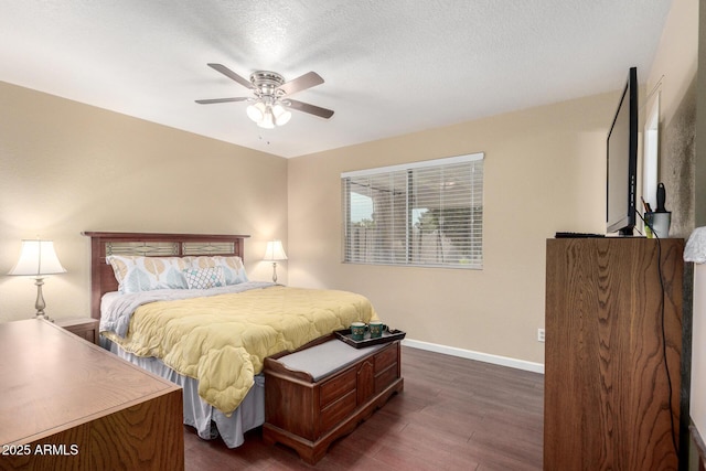 bedroom with ceiling fan, dark hardwood / wood-style flooring, and a textured ceiling