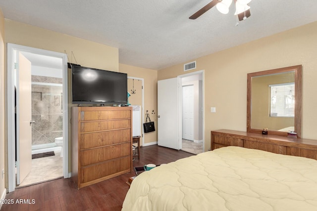 bedroom featuring ensuite bathroom, ceiling fan, dark hardwood / wood-style flooring, and a textured ceiling