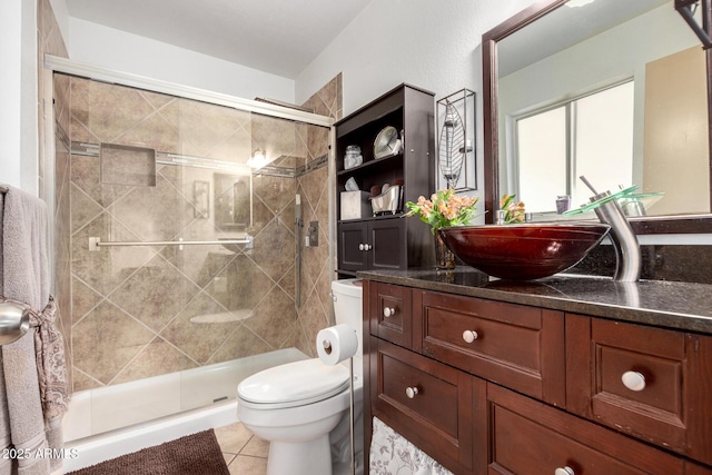 bathroom featuring an enclosed shower, vanity, toilet, and tile patterned flooring