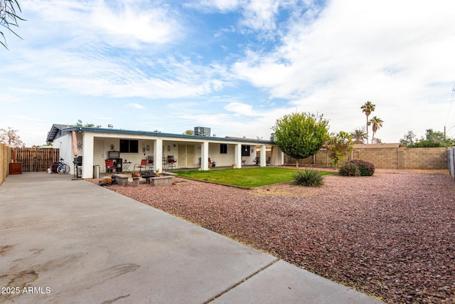 view of front of home featuring a front lawn, a patio, and central AC unit