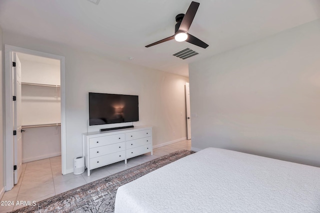 bedroom with a spacious closet, a closet, ceiling fan, and light tile patterned floors