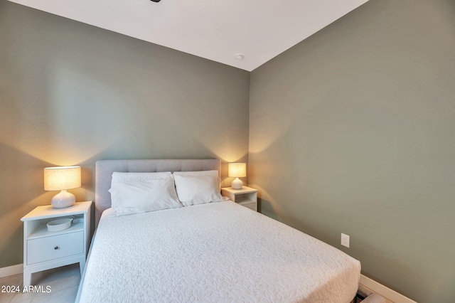 tiled bedroom featuring vaulted ceiling