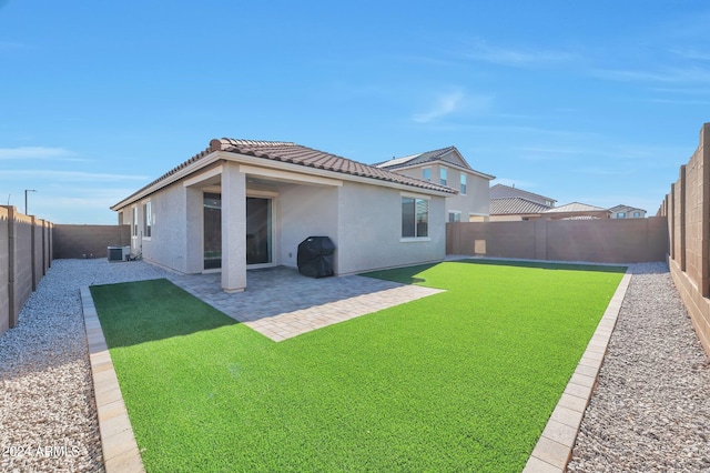 back of house with central AC unit, a yard, and a patio area