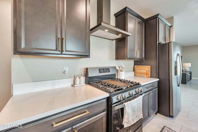 kitchen with light stone counters, wall chimney range hood, stainless steel appliances, light tile patterned floors, and dark brown cabinetry