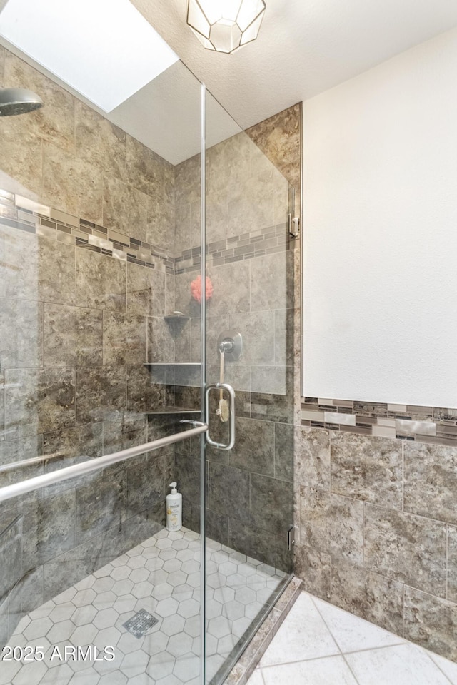 bathroom with tile patterned floors and a shower with shower door