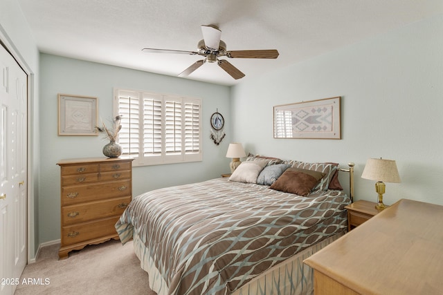 carpeted bedroom featuring ceiling fan and a closet