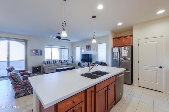 kitchen featuring appliances with stainless steel finishes, an island with sink, sink, hanging light fixtures, and ceiling fan