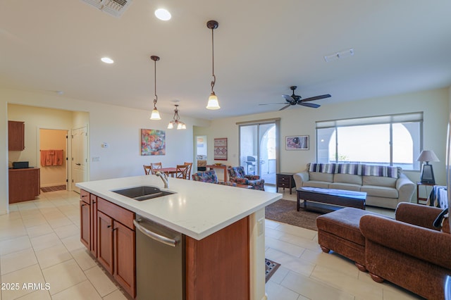 kitchen featuring sink, a healthy amount of sunlight, a center island with sink, decorative light fixtures, and stainless steel dishwasher