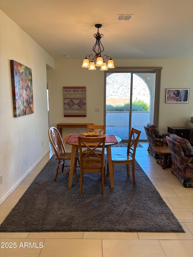 tiled dining room featuring an inviting chandelier