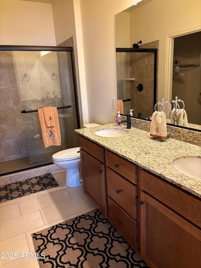 bathroom featuring vanity, tile patterned flooring, a shower with shower door, and toilet