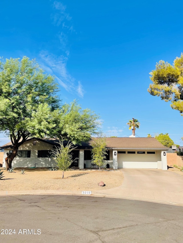 view of front facade featuring an attached garage, concrete driveway, and stucco siding