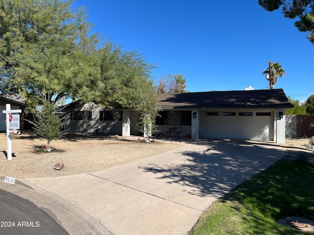 single story home featuring driveway, an attached garage, and stucco siding