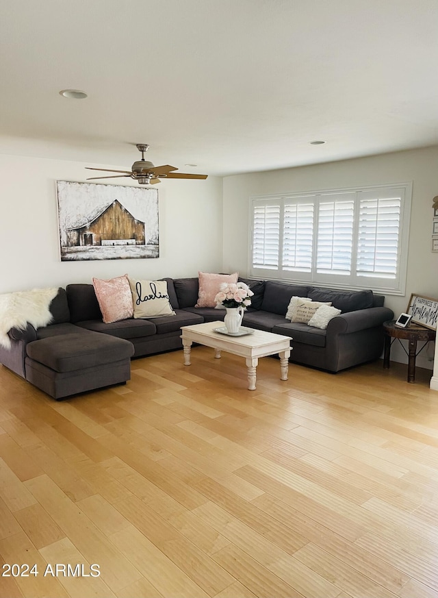 living area featuring light wood-type flooring and ceiling fan