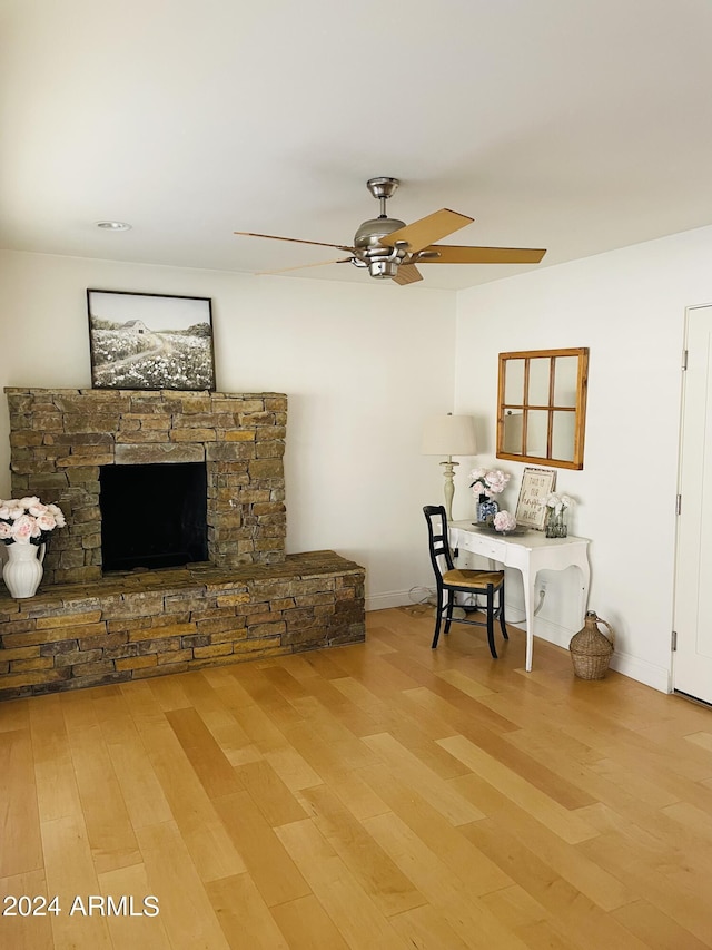 unfurnished living room with ceiling fan, a fireplace, and wood finished floors