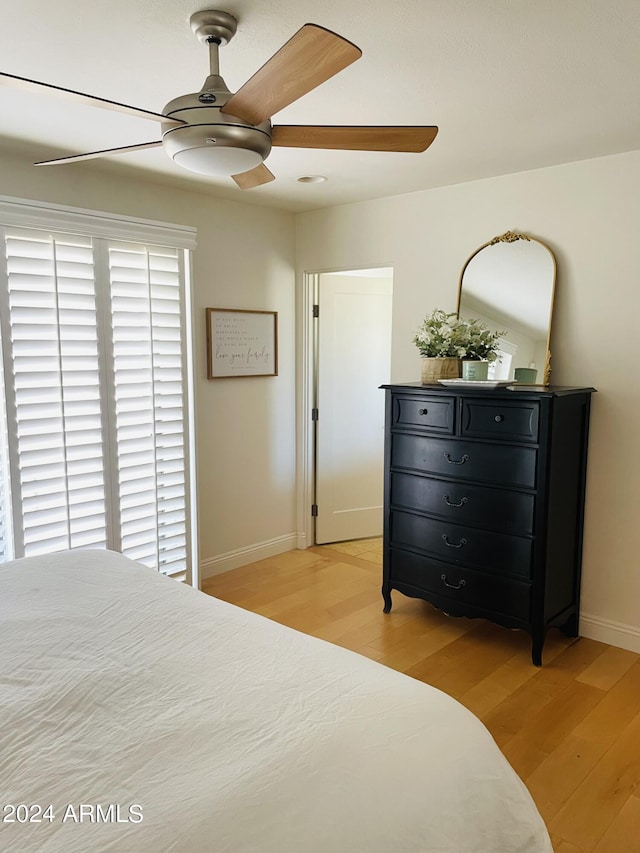 bedroom with baseboards, ceiling fan, and light wood finished floors