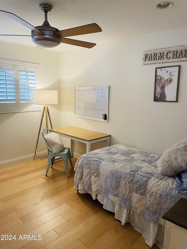 bedroom featuring light wood-style floors, baseboards, and a ceiling fan