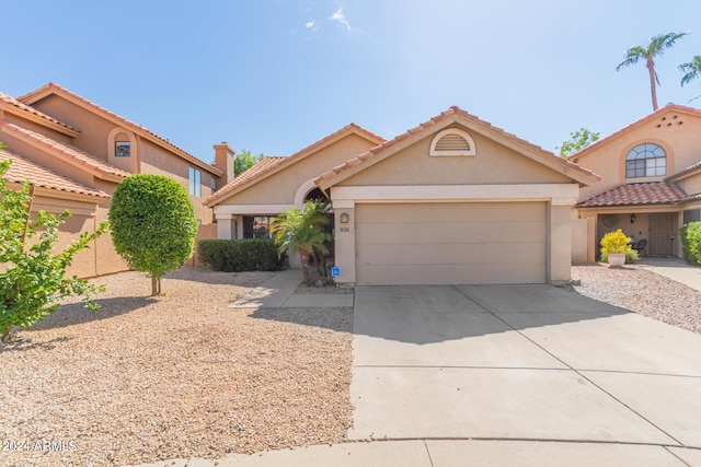 mediterranean / spanish house featuring a tile roof, stucco siding, concrete driveway, and a garage