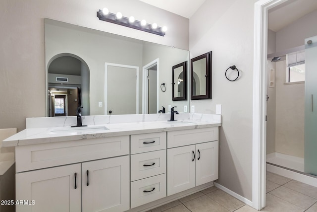 full bath with a sink, visible vents, a shower stall, and tile patterned floors